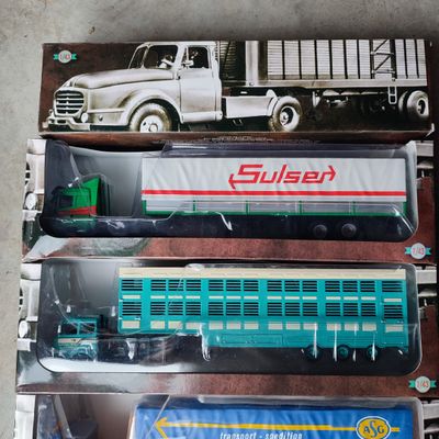 trois petits trains dans la boîte posée par terre