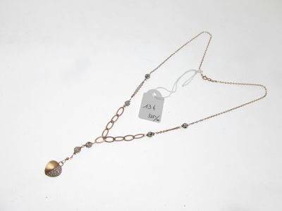 un gros plan d'un collier posé sur une surface blanche, muni d'une étiquette