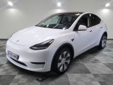 the white tesla suv is parked on a checkered tile floor
