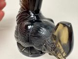 a black and gold vase with a bird on it ' s head