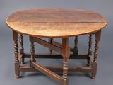 une vieille table en bois aux pieds tournés et au plateau rond