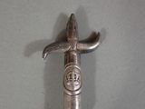 a silver knife with a crown on it on a table