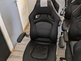 de nombreuses chaises de bureau en cuir noir alignées en rang