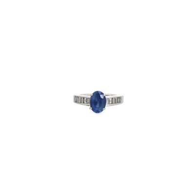 a close up of a ring with a blue stone on a white background