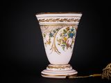 a white vase with gold trim and flowers on it