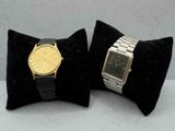 une paire de deux montres-bracelets posées sur une table, dans des étuis en velours noir