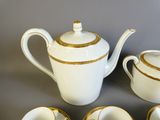 quatre tasses et une théière posées sur une table