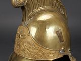 an antique brass helmet on a black background with a gray background
