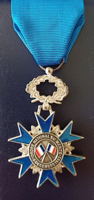 médaille avec un ruban bleu et un ruban bleu qui l'entoure, sur un fond noir