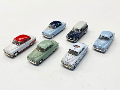 plusieurs petites voitures sont alignées sur une surface blanche
