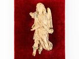an antique carved ivory figurine of an angel on a red velvet surface