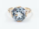 a gold ring with a blue topaz stone in the center