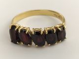 a close up of a gold ring with garnets on it