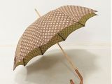 un parapluie marron et blanc avec un manche en bois