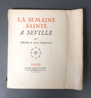 an old book with a red and black cover on a table