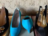 three pairs of blue and black shoes sitting on top of boxes