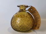 un petit vase en verre jaune sur lequel est accrochée une étiquette