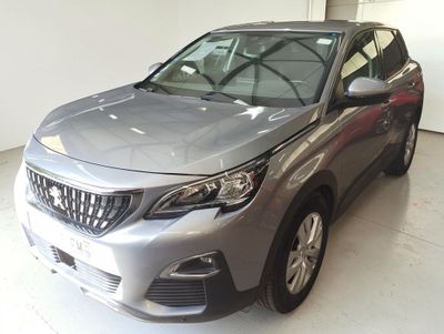 La voiture argentée est garée dans le garage de l'immeuble.