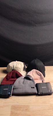 a cell phone, wallet, hat, and other items on a table