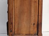 a small wooden cabinet with a door on top of it