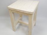 une image représentant un petit tabouret en bois blanc sur fond blanc