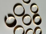 several gold rings are arranged in a circle on a white surface
