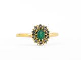 une bague en or sertie d'une pierre verte entourée de petits diamants blancs