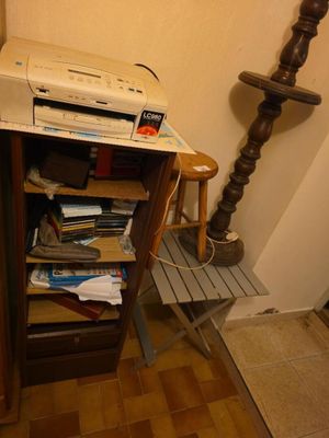 une imprimante posée sur un meuble, à côté d'une lampe