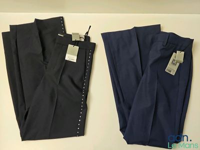deux paires de pantalons pour homme, encore étiquetés, posées sur une table