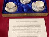 a box with a set of tea cups and saucers in it