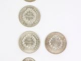 six types de pièces différents alignés sur une surface blanche