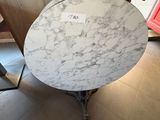 une table en marbre sur laquelle est posé un panneau, dans un magasin