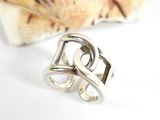 sterling silver ring with two inter links on top of a seashell