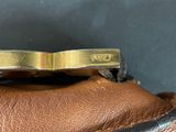 brown leather handbag with a gold buckle on top of it