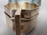 a silver container with a spoon in it on a table