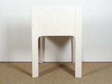 a small white chair sitting on top of a carpeted floor