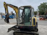 an image of a small excavator parked in a parking lot