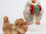 un petit chien debout à côté d'une peluche