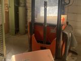 a forklift in a garage with a box on the floor