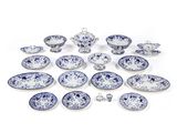 Des assiettes et des bols en porcelaine bleue et blanche sont disposés sur une surface blanche