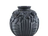 un vase noir orné d'un motif sur fond blanc