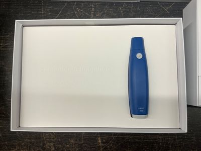 un objet bleu et blanc dans une boîte posée sur une table