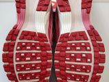 a close up of a pair of red shoes on a white surface