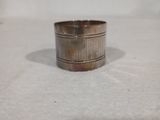 une bague en argent posée sur une surface blanche