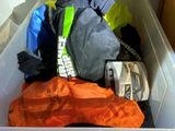 a plastic container filled with clothes and a cell phone