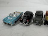 four toy cars are lined up in a row on a white surface
