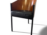 a wooden chair with a black leather seat on a white background