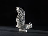 a glass figurine of a rooster on a black surface