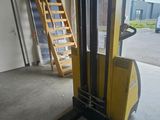 a forklift in a warehouse with a ladder