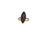 un gros plan d'une bague sertie de diamants noirs sur fond blanc